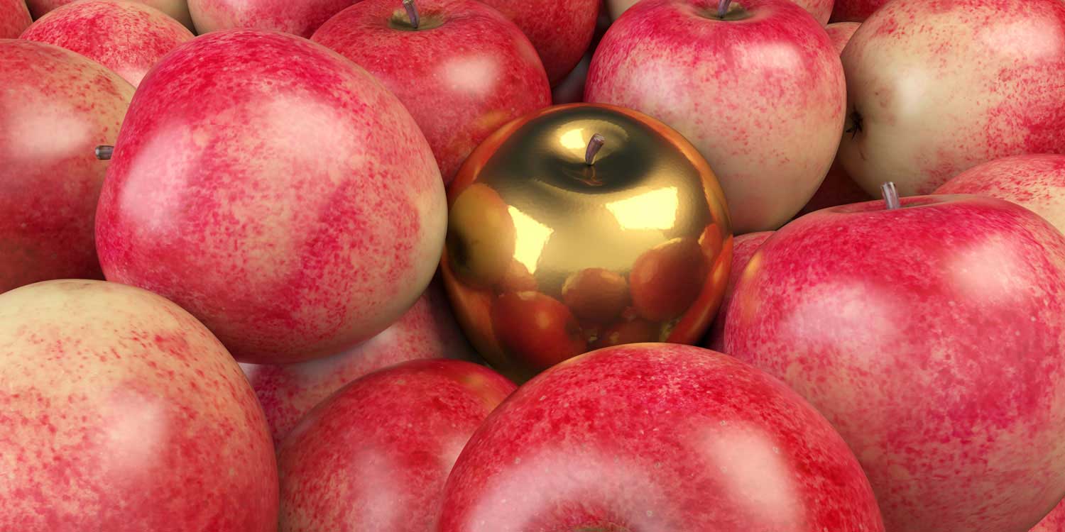 A golden apple among many red apples