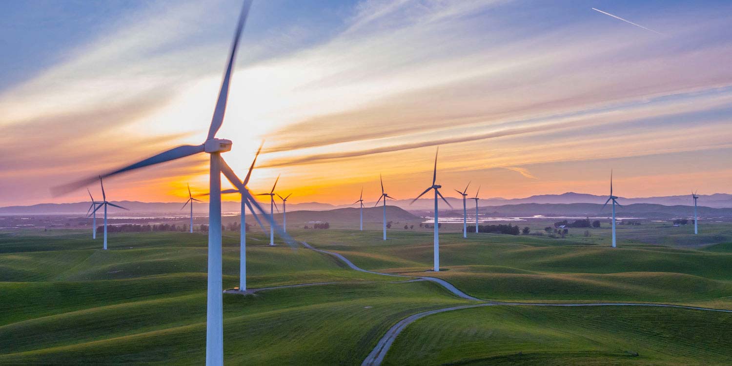 A wind farm with the sun setting