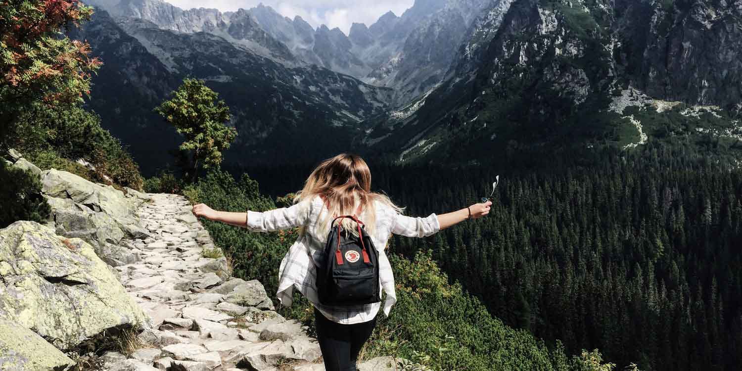 A woman standing on the edge of a valley looking into the distance