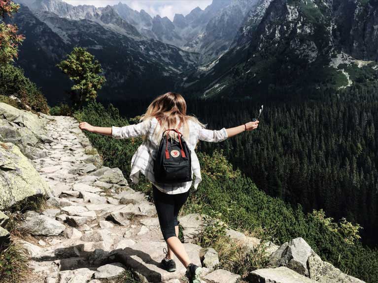 A woman standing on the edge of a valley looking into the distance