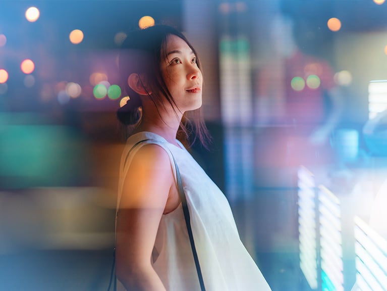 Young Asian businesswoman looking at financial data, standing in front of digital display