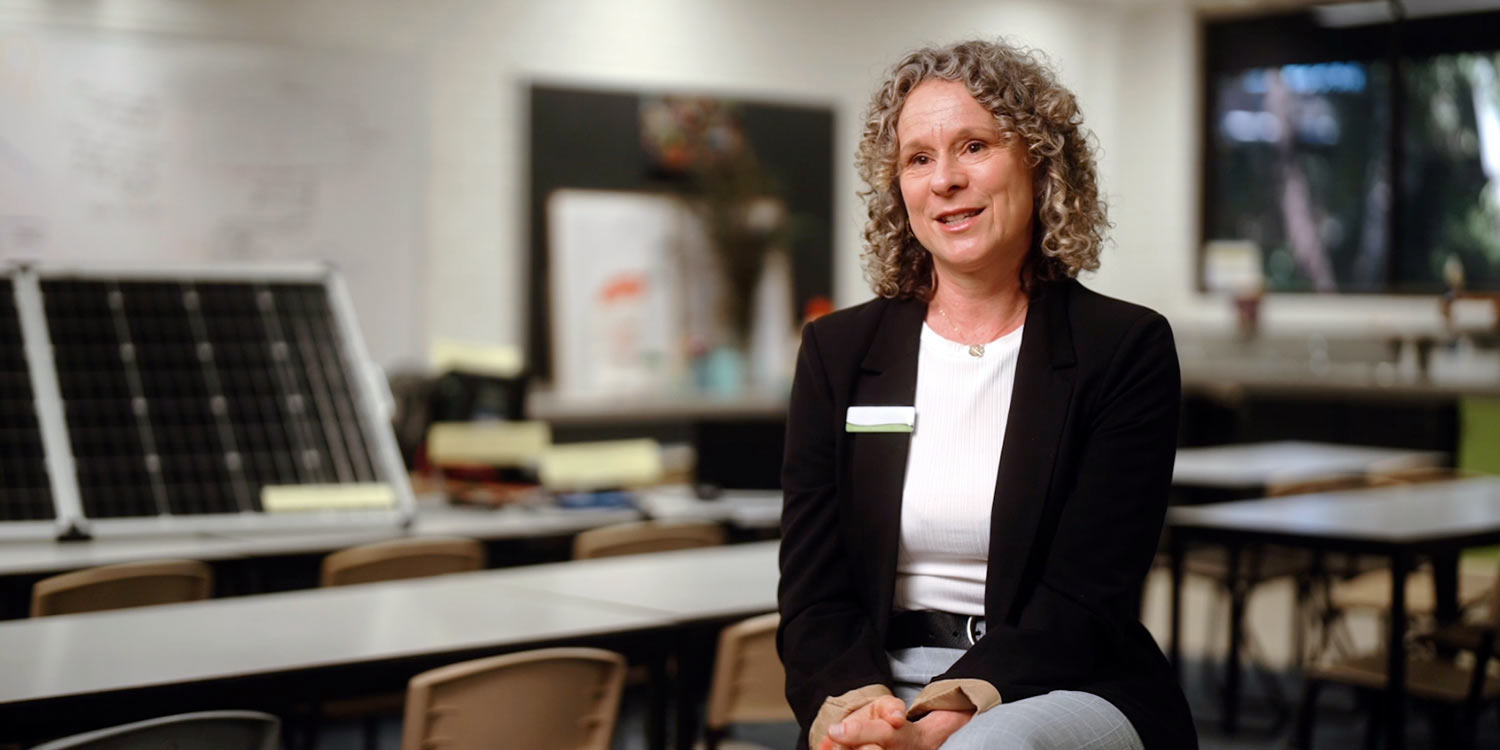 Jennifer Greenland sitting on a chair in a school