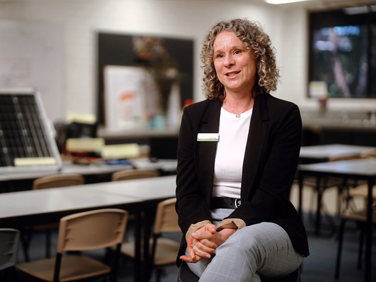 Jennifer Greenland sitting on a chair in a school